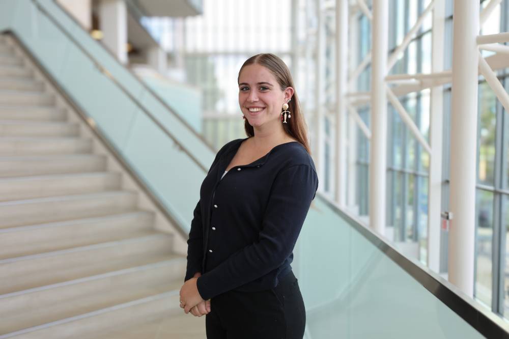 Image 1 of 2 Woman posing on library stairs, smiling